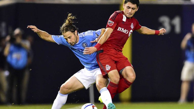 New York City FC midfielder Ned Grabavoy and Toronto FC midfielder Marco Delgado battle for the ball in an MLS game at Yankee Stadium on Wednesday, Sept. 16, 2015.