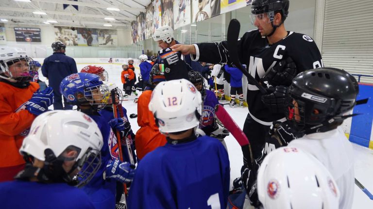 John Tavares #91 of the New York Islanders hands out the team's third uniform to youth hockey players during a skate on Sept. 15, 2015 at Iceworks in Syosset.