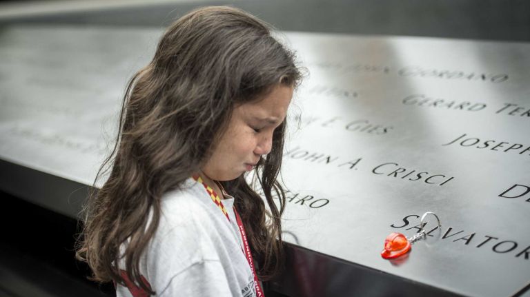 Eight-year-old Gianna Calabro weeps as she thinks about her uncle, FDNY firefighter Salvatore Calabro, who died during the Sept. 11 terror attacks. Friends and families gather at Ground Zero on Friday, Sept. 11, 2015, to honor and remember those killed 14 years ago.