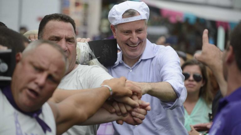 New York City Mayor Bill de Blasio helps lift a 3-ton, 80-foot-tall Giglio tower in Williamsburg, Brooklyn, on Sunday, July 13, 2014. The Giglio lift is a tradition in which more than 250 men recreate the return of St. Paulinus, the bishop of Nola.