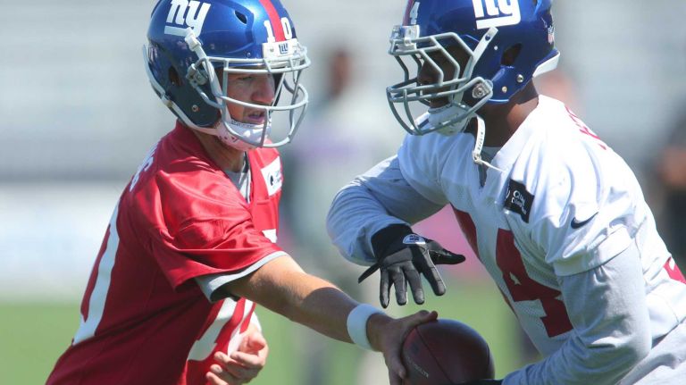 New York Giants quarterback Eli Manning hands off to running back Andre Williams during training camp at the Quest Diagnostics Training Center in East Rutherford, N.J. on Friday, Aug. 7, 2015.