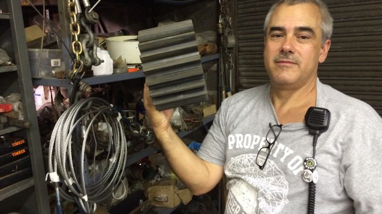 Steve Vourderis, a co-owner of the Wonder Wheel and its chief mechanic, holds up a replacement plastic gear for the ride, on July 20, 2015. 