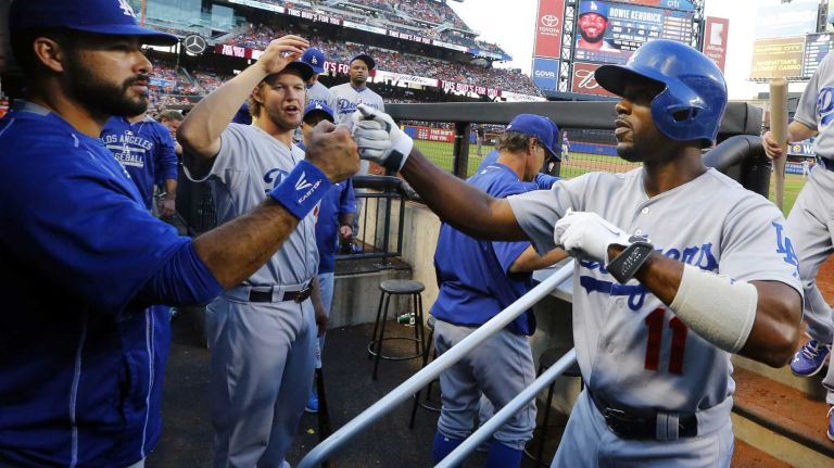 Jimmy Rollins of the Los Angeles Dodgers celebrates in the dugout after scoring in the second inning against the Mets at Citi Field on Friday, July 24, 2015.