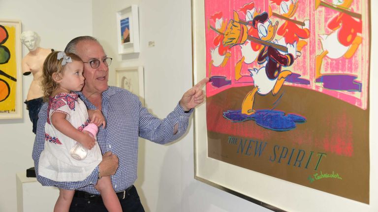 Syndey Wiener and Andy Marcus check out the Andy Warhol Daffy Duck artwork at Art Southampton at Nova's Ark on July 10, 2015 in Water Mill.