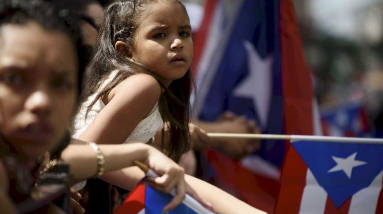 Spectators line Fifth Avenue in midtown Sunday, June 14, 2015, awaiting the National Puerto Rican Day Parade. The parade has marched through Manhattan for more than 50 years.