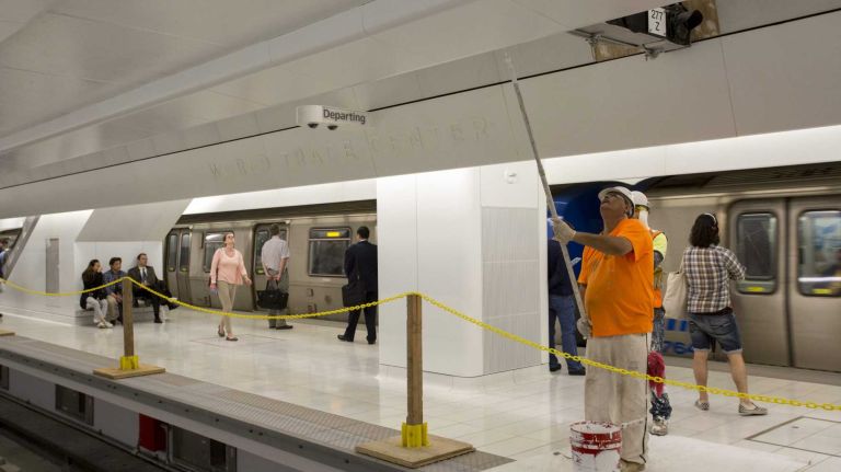 Workers paint on Platform A of the PATH station. 