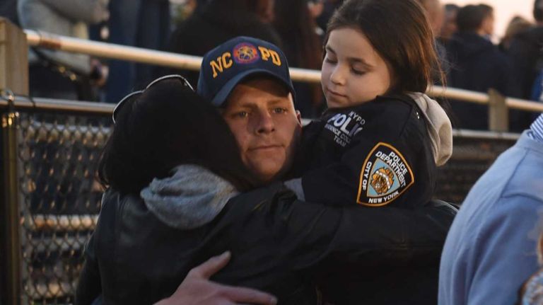 Family and friends of slain NYPD Police Officer Brian Moore gather at a memorial service for him on the football field of Plainedge High School on Monday, May 4, 2015.
