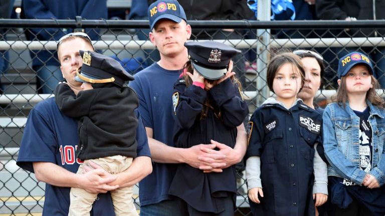 Family of slain NYPD Police Officer Brian Moore gather at a memorial service for him on the football field of Plainedge High School, his alma mater, on Monday, May 4, 2015.