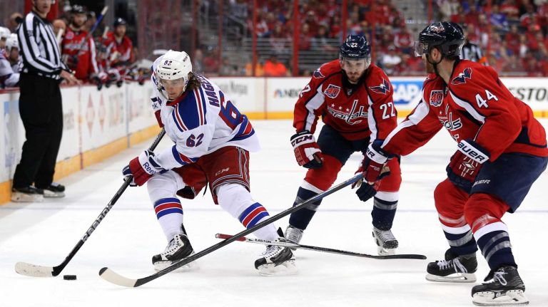 Carl Hagelin #62 of the New York Rangers skates past Brooks Orpik #44 and Curtis Glencross #22 of the Washington Capitals during the second period in Game 3 of the Eastern Conference semifinals during the 2015 NHL Stanley Cup playoffs at Verizon Center on May 4, 2015 in Washington.