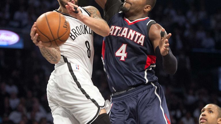 The Brooklyn Nets' Deron Williams passes the ball while getting defensive pressure from Paul Millsap of the Atlanta Hawks in the third quarter of Game 4 of the first round of the NBA playoffs at the Barclays Center on Monday, April 27, 2015.