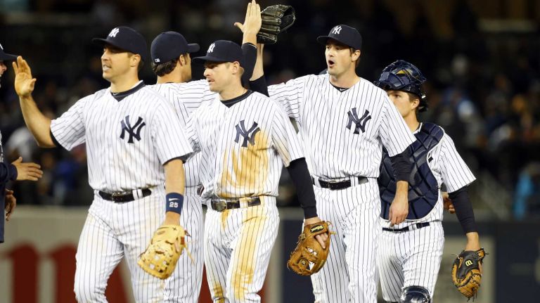 Andrew Miller #48 of the New York Yankees celebrates the final out of a game against the New York Mets with his teammates at Yankee Stadium on Sunday, April 26, 2015.