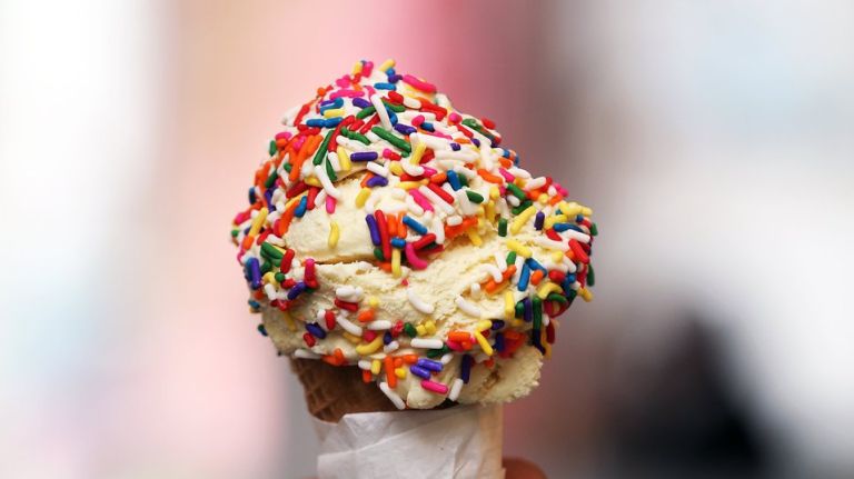 A scoop of vanilla ice cream with rainbow sprinkles.