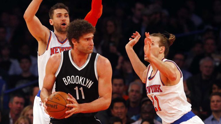 Brook Lopez of the Brooklyn Nets controls the ball against Andrea Bargnani and Lou Amundson of the New York Knicks at Madison Square Garden on Wednesday, April 1, 2015.