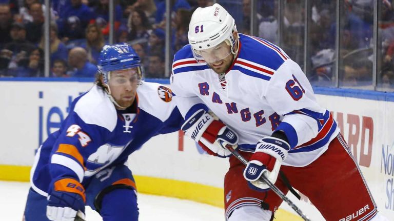 Rick Nash 32 Rick Nash of the New York Rangers tries to control the puck against Calvin de Haan of the New York Islanders at Nassau Coliseum on Tuesday, Jan. 27, 2015.