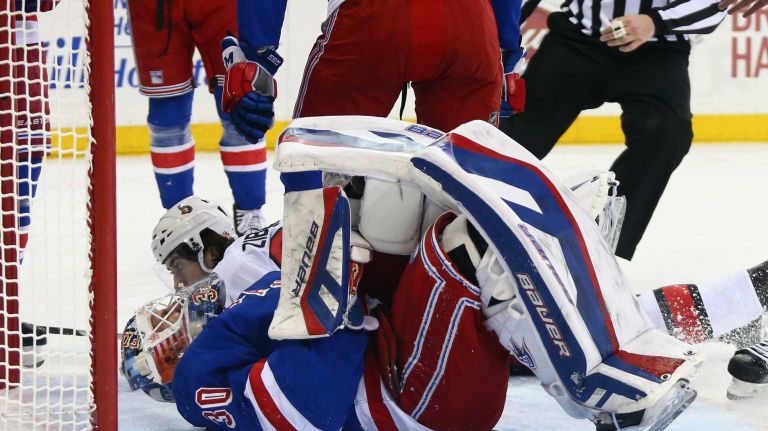 NEW YORK, NY - APRIL 09: Henrik Lundqvist #30 of the New York Rangers shows the effects of being interferered with by Mika Zibanejad #93 of the Ottawa Senators during the first period at Madison Square Garden on April 9, 2015 in New York City. (Photo by Bruce Bennett/Getty Images)