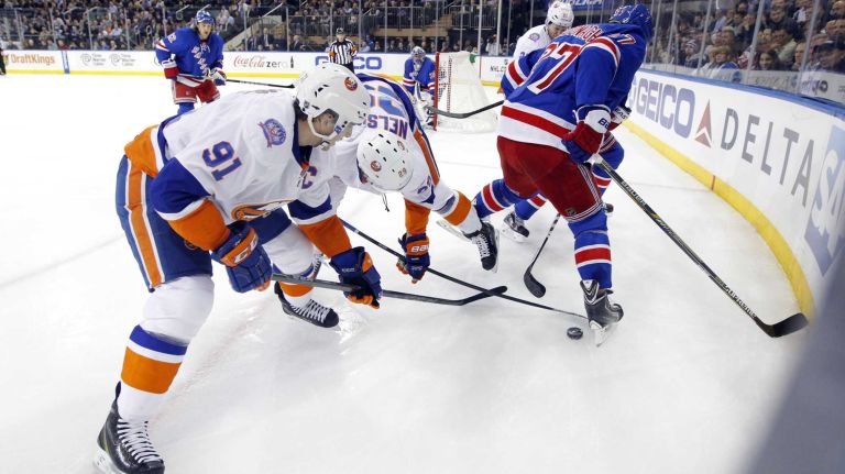 John Tavares and Brock Nelson of the New York Islanders play the puck against Ryan McDonagh of the New York Rangers at Madison Square Garden on Tuesday, Jan. 13, 2015.