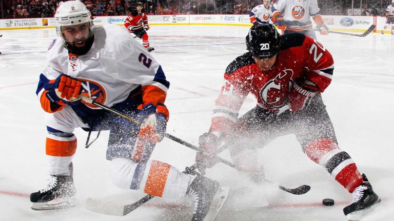 Nick Leddy of the New York Islanders and Jordin Tootoo of the New Jersey Devils battle for the puck during the second period at the Prudential Center on Jan. 9, 2015 in Newark, N.J.
