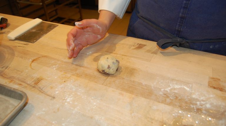Roll it against the work surface to form a ball. Continue to roll until the dough is completely smooth. Repeat with the remaining dough. 