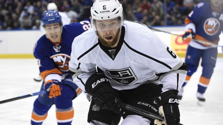 Los Angeles Kings defenseman Jake Muzzin chases the puck ahead of New York Islanders center Anders Lee in the third period of an NHL hockey game at Nassau Coliseum on Thursday, March 26, 2015. The Kings defeated the Islanders 3-2.