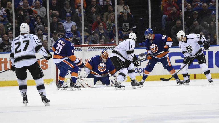 Los Angeles Kings center Anze Kopitar #11 tips in a goal against New York Islanders goalie Jaroslav Halak in the third period of an NHL hockey game at Nassau Coliseum on Thursday, March 26, 2015. The Kings defeated the Islanders 3-2.