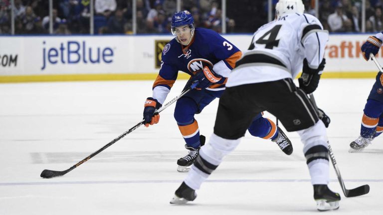 New York Islanders defenseman Travis Hamonic skates with the puck against Los Angeles Kings defenseman Robyn Regehr in the third period of an NHL hockey game at Nassau Coliseum on Thursday, March 26, 2015. The Kings defeated the Islanders 3-2.
