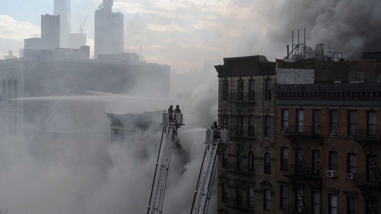 East Village building explosion: Photos 17 New York City firefighters on ladders spray water at the scene of a fire and a partial building collapse in the East Village neighborhood of New York on Thursday, March 26, 2015.