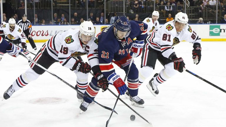 Jonathan Toews of the Chicago Blackhawks battles for the puck against Derek Stepan of the New York Rangers at Madison Square Garden on Wednesday, March 18, 2015.