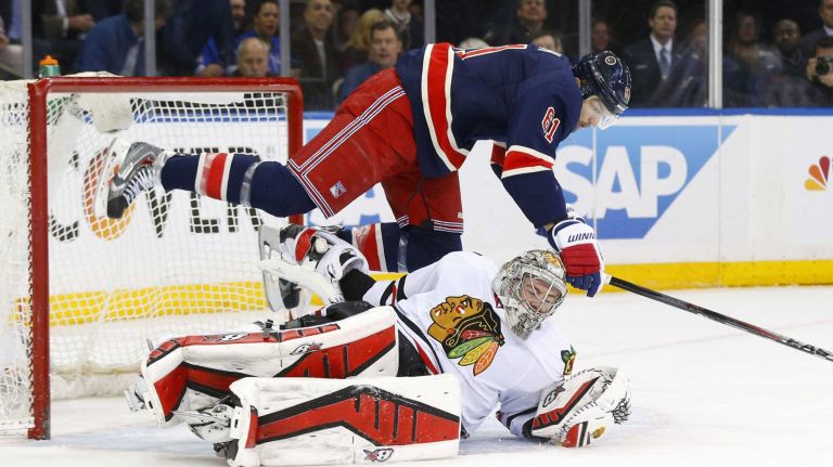Rick Nash of the New York Rangers falls over Scott Darling of the Chicago Blackhawks after a missed scoring chance in the first period at Madison Square Garden on Wednesday, March 18, 2015 in New York City.