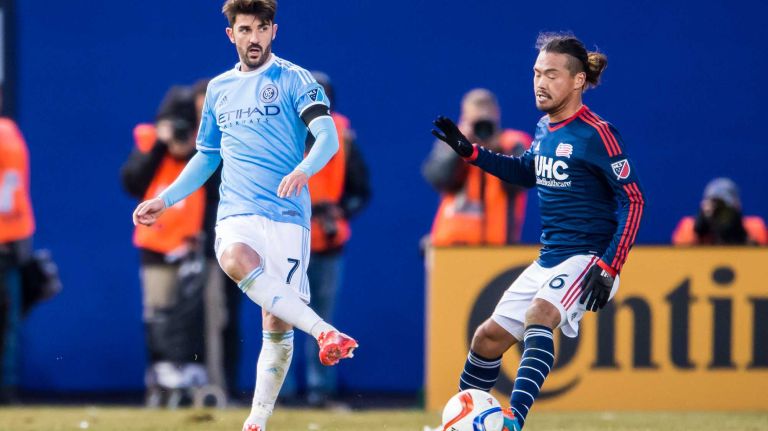 New York City FC forward David Villa (7) passes the ball under pressure from New England Revolution midfielder Daigo Kobayashi (16) during a game at Yankee Stadium on Sunday, March 15, 2015.