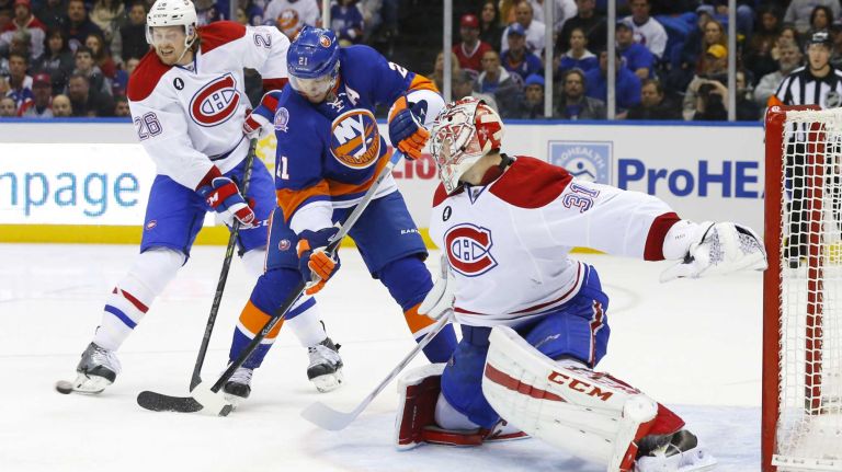 Jeff Petry and Carey Price of the Montreal Canadiens defend a third period scoring chance against Kyle Okposo of the New York Islanders at Nassau Coliseum on Saturday, March 14, 2015 in Uniondale.