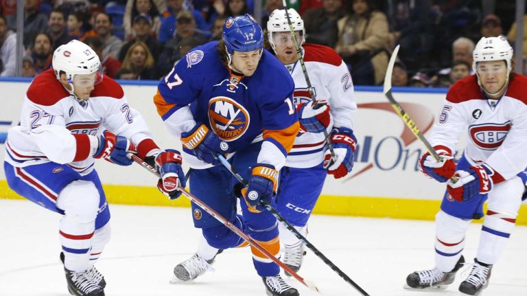 Matt Martin of the New York Islanders tries to control the puck in the first period as he is surrounded by Alex Galchenyuk, Dale Weise and P.A. Parenteau of the Montreal Canadiens at Nassau Coliseum on Saturday, March 14, 2015.
