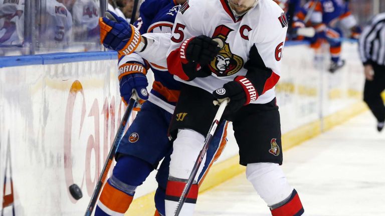 Erik Karlsson of the Ottawa Senators defends against Casey Cizikas of the New York Islanders at Nassau Coliseum on Friday, March 13, 2015.