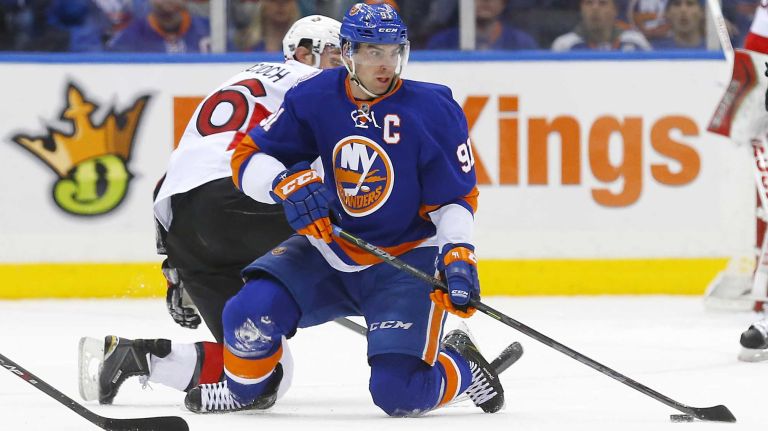 John Tavares of the New York Islanders plays the puck in the second period against Patrick Wiercioch of the Ottawa Senators at Nassau Coliseum on Friday, March 13, 2015.