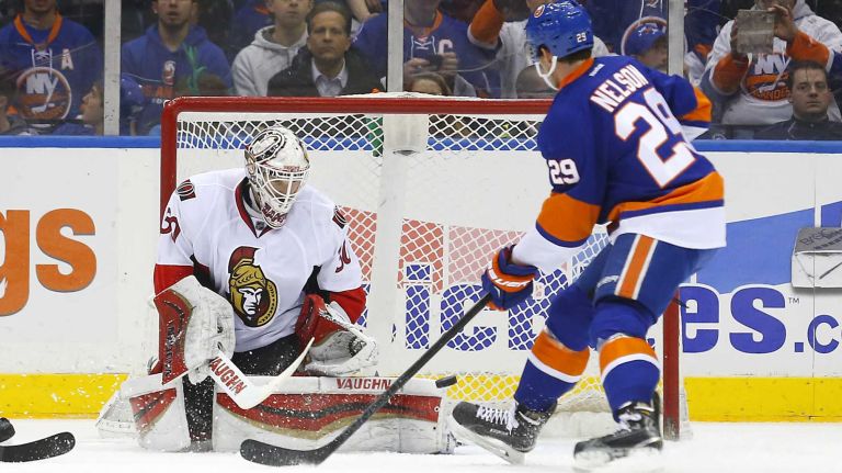 Andrew Hammond of the Ottawa Senators makes a save in the second period save as Brock Nelson of the New York Islanders looks for a rebound at Nassau Coliseum on Friday, March 13, 2015.