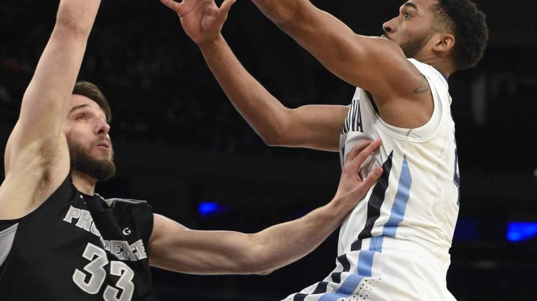 Villanova Wildcats guard Darrun Hilliard II sinks a layup against Providence Friars forward Carson Desrosiers in a Big East semifinal men's basketball game at Madison Square Garden on Friday, March 13, 2015.