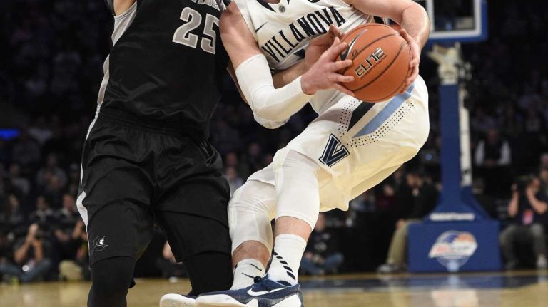 Villanova Wildcats guard Ryan Arcidiacono is defended by Providence Friars forward Tyler Harris in a Big East semifinal men's basketball game at Madison Square Garden on Friday, March 13, 2015.