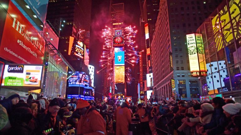 Fireworks explode overhead as revelers celebrate New Year's Eve in Times Square on Dec. 31, 2014.