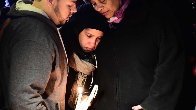 Mourners embrace during a gathering at a memorial for slain NYPD Officers Rafael Ramos and Wenjian Liu on Sunday, Dec. 21, 2014. The two were fatally shot a day before in an ambush attack near the intersection of Myrtle and Tompkins avenues. 