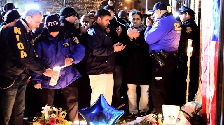 Officers gather at a memorial for slain NYPD comrades Rafael Ramos and Wenjian Liu.