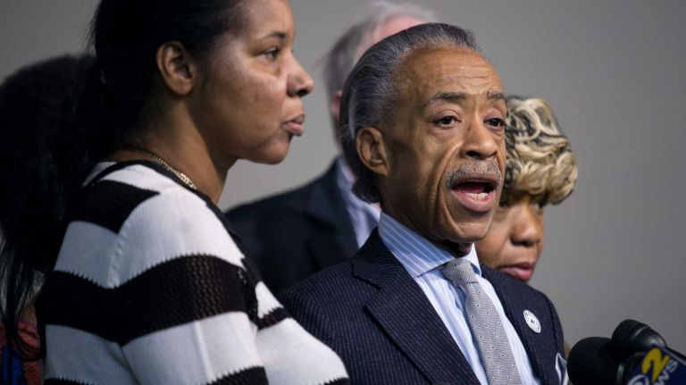 The Rev. Al Sharpton stands with Esaw Garner, left, wife of Eric Garner, and Gwen Carr, right, mother of Eric Garner, as they denounced violence in their loved one's name Sunday, Dec. 21, 2014, at the National Action Network headquarters in Harlem, in the wake or the shooting deaths of NYPD officers Wenjian Liu and Rafael Ramos.