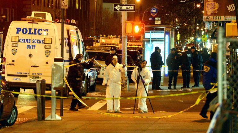 Investigators work in the area where two NYPD officers were shot and killed in the Bedford-Stuyvesant neighborhood of Brooklyn on Saturday, Dec. 20, 2014.
