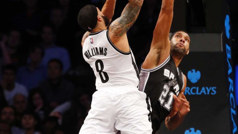 Deron Williams of the Brooklyn Nets goes to the hoop against Tim Duncan of the San Antonio Spurs during an NBA game at Barclays Center on Wednesday, Dec. 3, 2014.