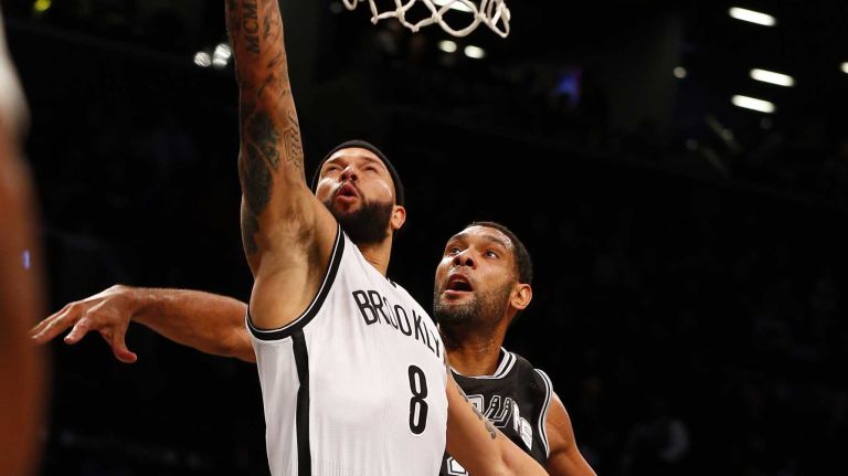 Deron Williams of the Brooklyn Nets goes to the hoop for a third quarter basket against Tim Duncan of the San Antonio Spurs during an NBA game at Barclays Center on Wednesday, Dec. 3, 2014.