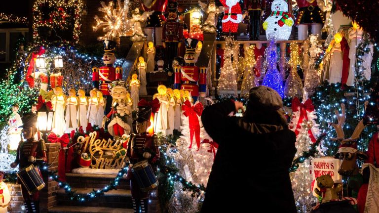 A visitor takes pictures of one of the elaborate Christmas display on 84th Street in Brooklyn's Dyker Heights.