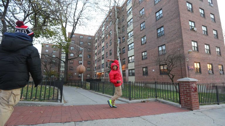 Ziyeer Smith, 12 ( in blue), and Taejon Tyson, 11 ( in red), play with a basketball outside the Soundview Houses on Seward Ave. in the Soundview section of the Bronx, Thursday, Nov., 20, 2014.
