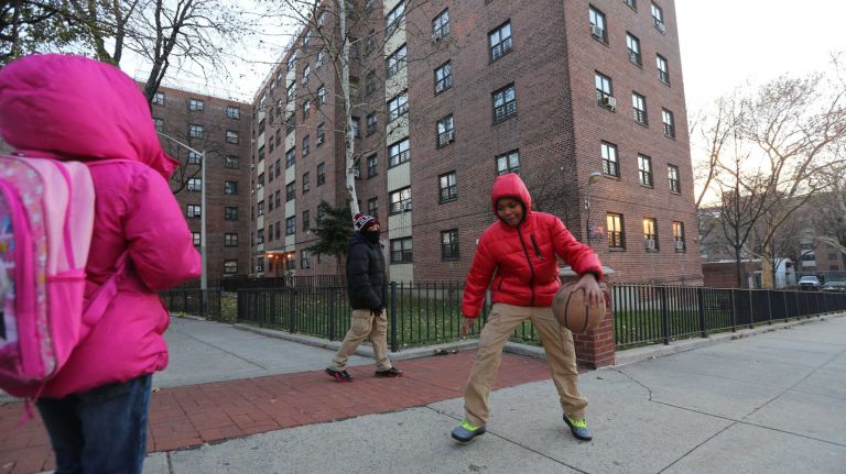 Ziyeer Smith, 12 ( in blue), and Taejon Tyson, 11 ( in red), play with a basketball outside the Soundview Houses on Seward Ave. in the Soundview section of the Bronx, Thursday, Nov., 20, 2014.