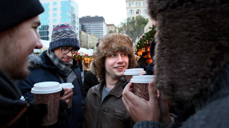 Center left, Benjamin Clousier, a college student visiting from France, and Valentin Goczol, a college student visiting from Belgium, toast hot apple cider with friends at the Union Square Holiday Market, Friday, Nov. 21, 2014.