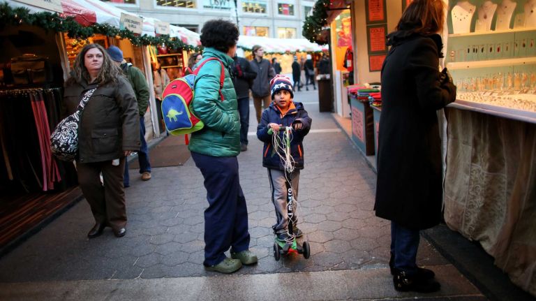 Sue Khan and her son, T. J. Khan, 6, from Manhattan, browse the Union Square Holiday Market, Friday, Nov. 21, 2014.