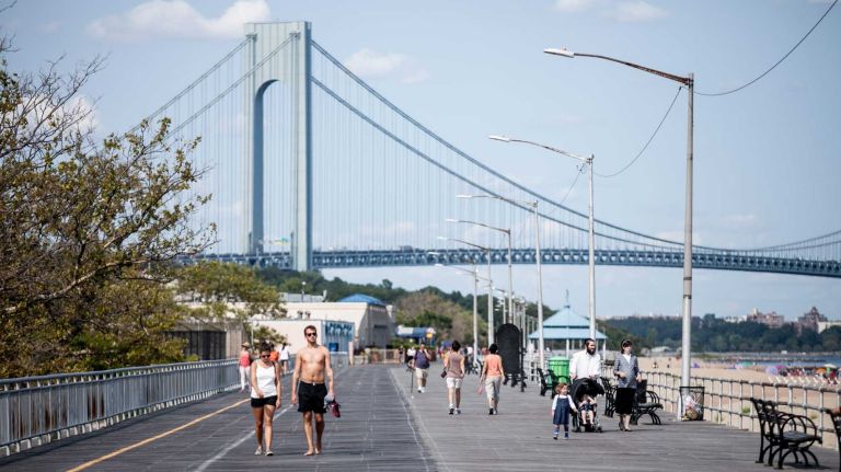 People walk along the boardwalk in South Beach.