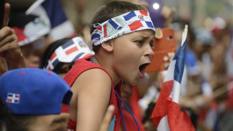 Spectators cheer during the 33rd annual Dominican Day Parade on Sixth Avenue in Manhattan on Sunday, Aug. 10, 2014.